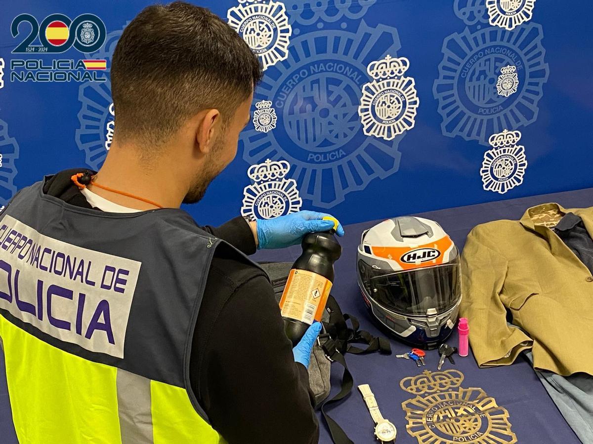 Un investigador muestra la botella intervenida.
