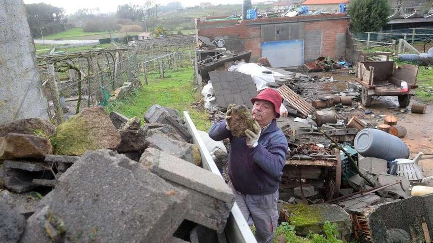 Los propietarios de un galpón destruido en San Martiño de Meis intentan limpiar la finca tras la retirada de las uralitas. // Noé Parga