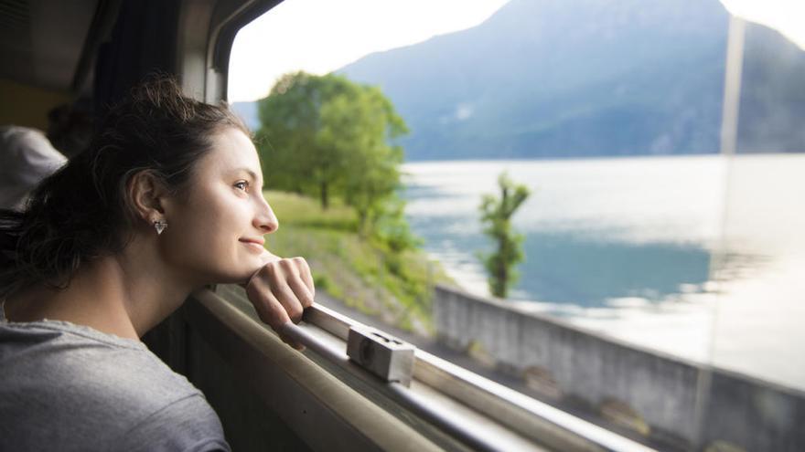 Una mujer disfruta de un viaje en tren.
