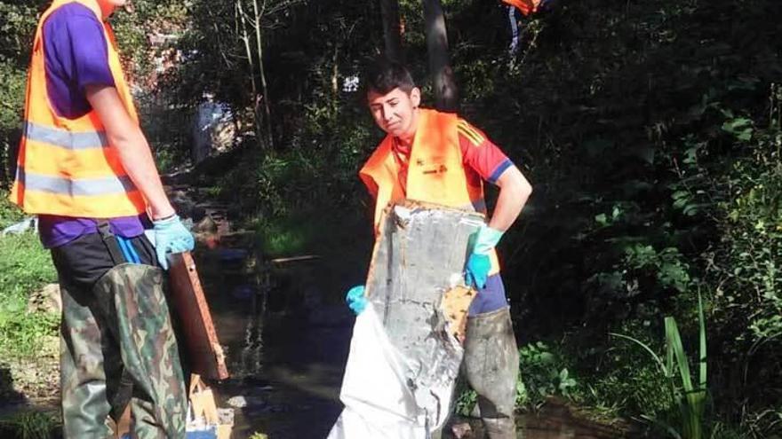 Participantes en la limpieza del río, durante los trabajos.