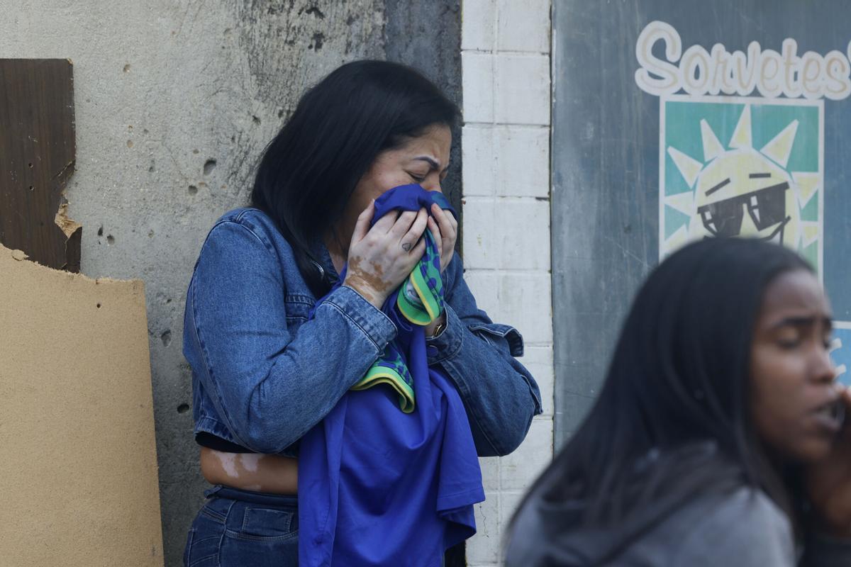 Una mujer llora en una calle donde se encuentran cuerpos sin vida este miércoles, en Río de Janeiro (Brasil). EFE/ Antonio Lacerda. ATENCIÓN EDITORES: CONTENIDO GRÁFICO EXPLICITO