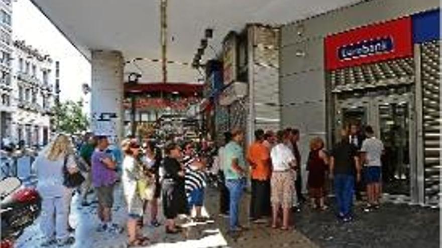 Cua de clients a la porta d&#039;entrada a una entitat bancària d&#039;Atenes.