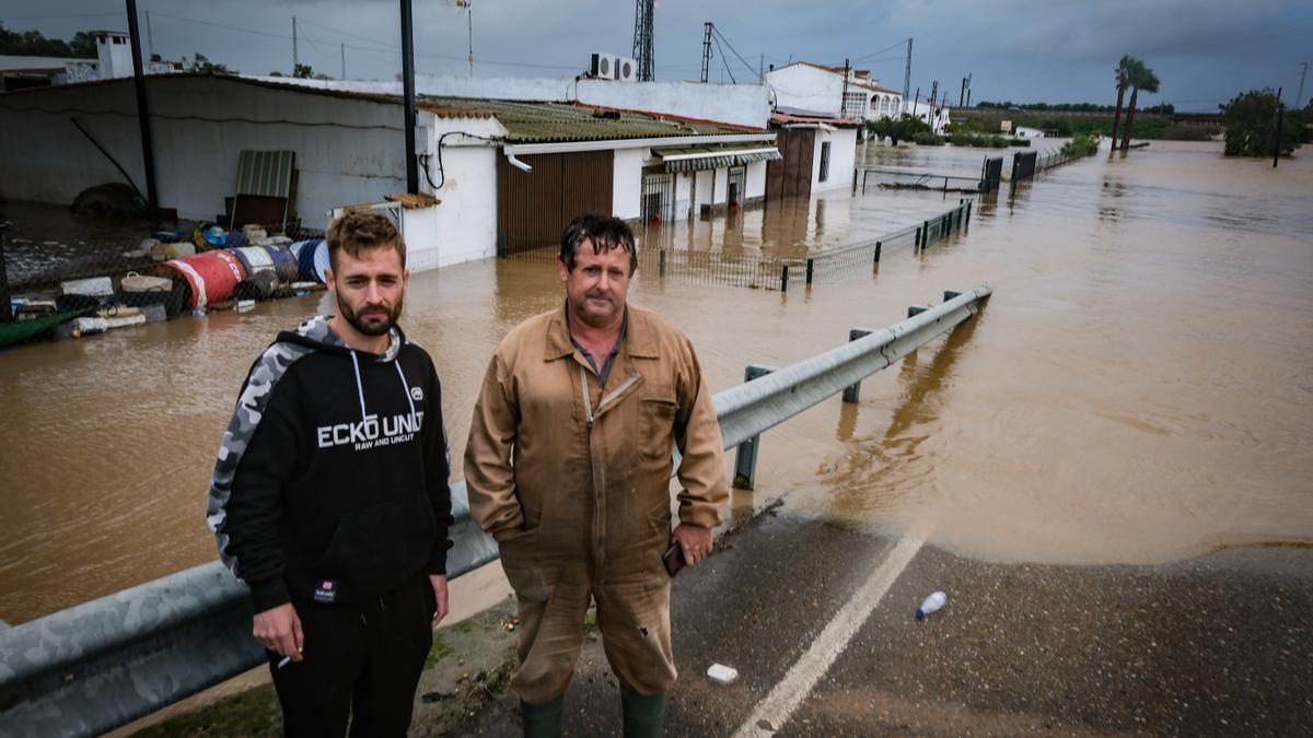 Pedro Traver (derecha) delante de su casa, con más de un metro de altura de agua.