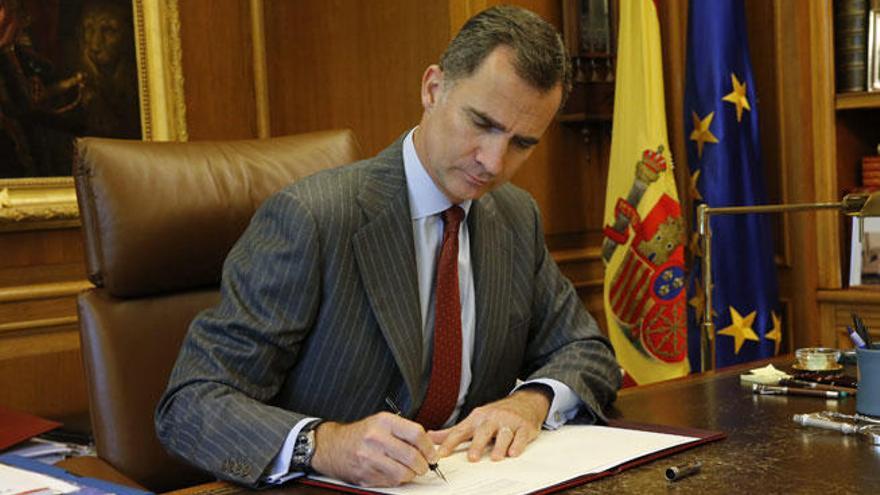 El Rey firmando la convocatoria de las elecciones.