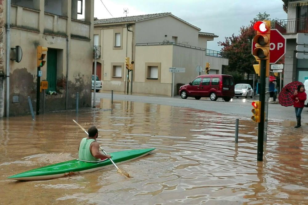 Un veí de Bordils va en kayak per un dels carrers del municipi que han quedat inundats