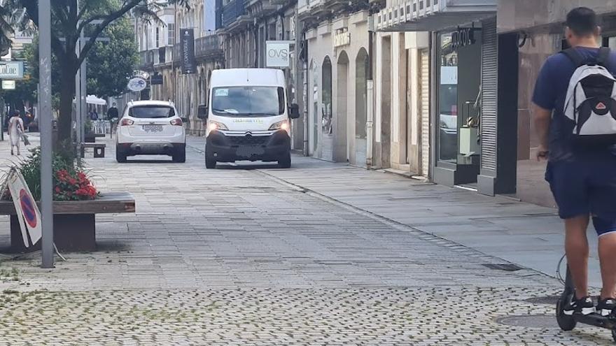 Un turismo estacionado en la calle peatonal Rey Daviña mientras un furgón realiza el reparto, dentro del horario establecido para ello.