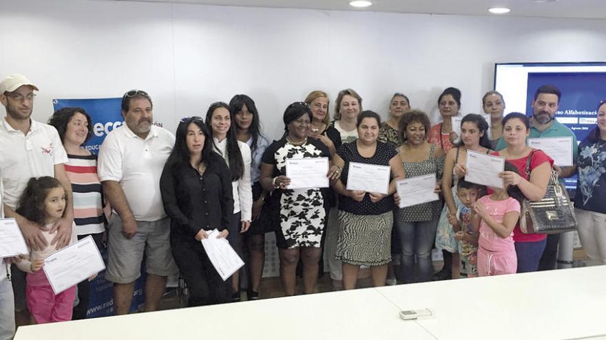 Los estudiantes del curso de alfabetización de adultos muestran sus diplomas junto a Carmela Silva.// FdV