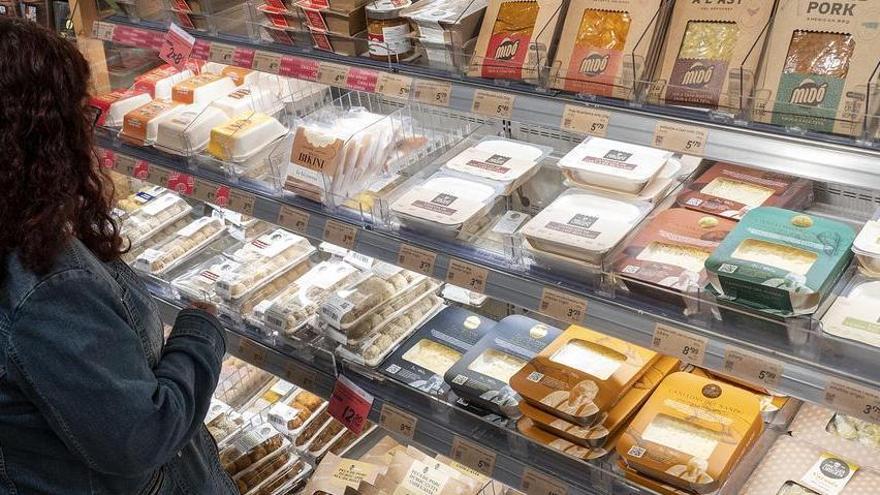 Una mujer observa la oferta disponible en la zona de platos precocinados en un supermercado