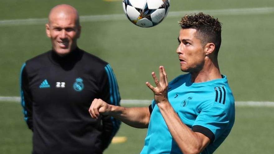 Zidane observa cómo Cristiano Ronaldo cabecea un balón.
