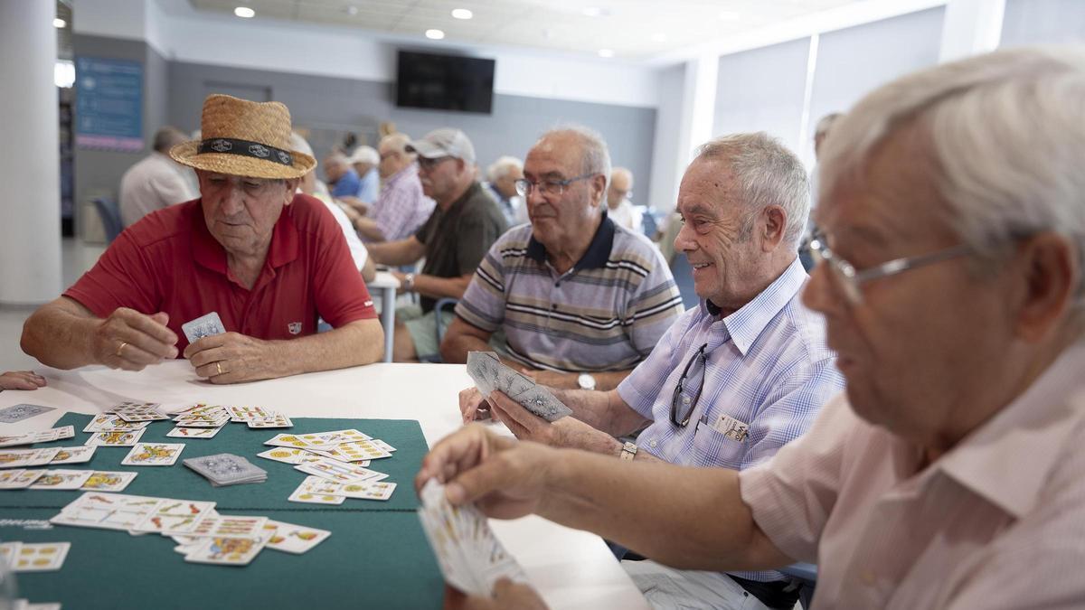 Un grup de persones jubilades juguen al dominó i a les cartes en el Casal de la Gent Gran Bellvitge-*LErmita / FERRAN NADEU/ EL PERIÓDICO