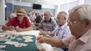 Un grupo de personas jubiladas juegan al dominó y a las cartas en el Casal de la Gent Gran Bellvitge-LErmita / FERRAN NADEU/ EL PERIÓDICO