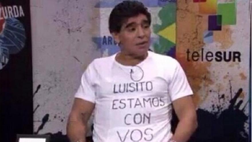 Maradona muestra una camiseta en apoyo a Luis Suárez