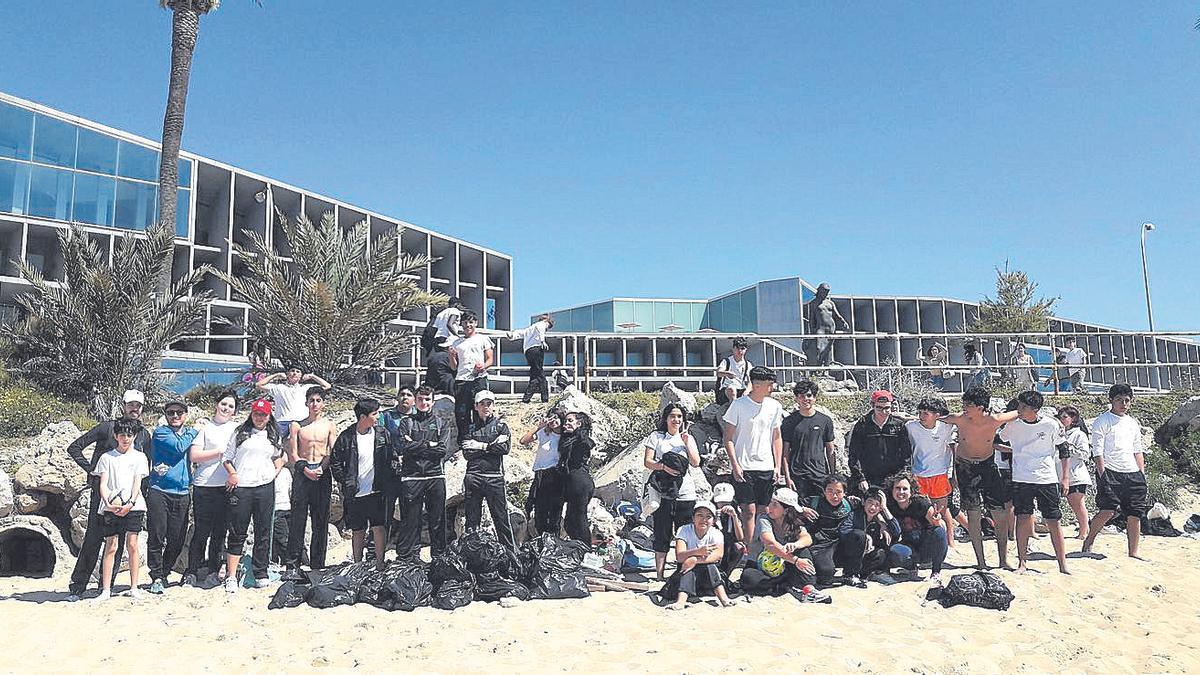 Los alumnos de secundaria del Colegio Sant Vicenç de Paül limpando la playa