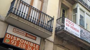 Barcelona. 24.04.2026. Economía. Cartel que anuncia pisos en venta junto a otro que anuncia local en alquiler en una finca de la calle Portaferrisa de Barcelona. Fotografía de Jordi Cotrina