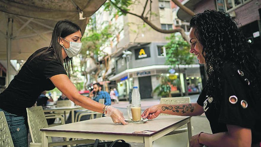 Una empleada de una cafetería de Santa Cruz sirve un &#039;barraquito&#039; a una clienta.