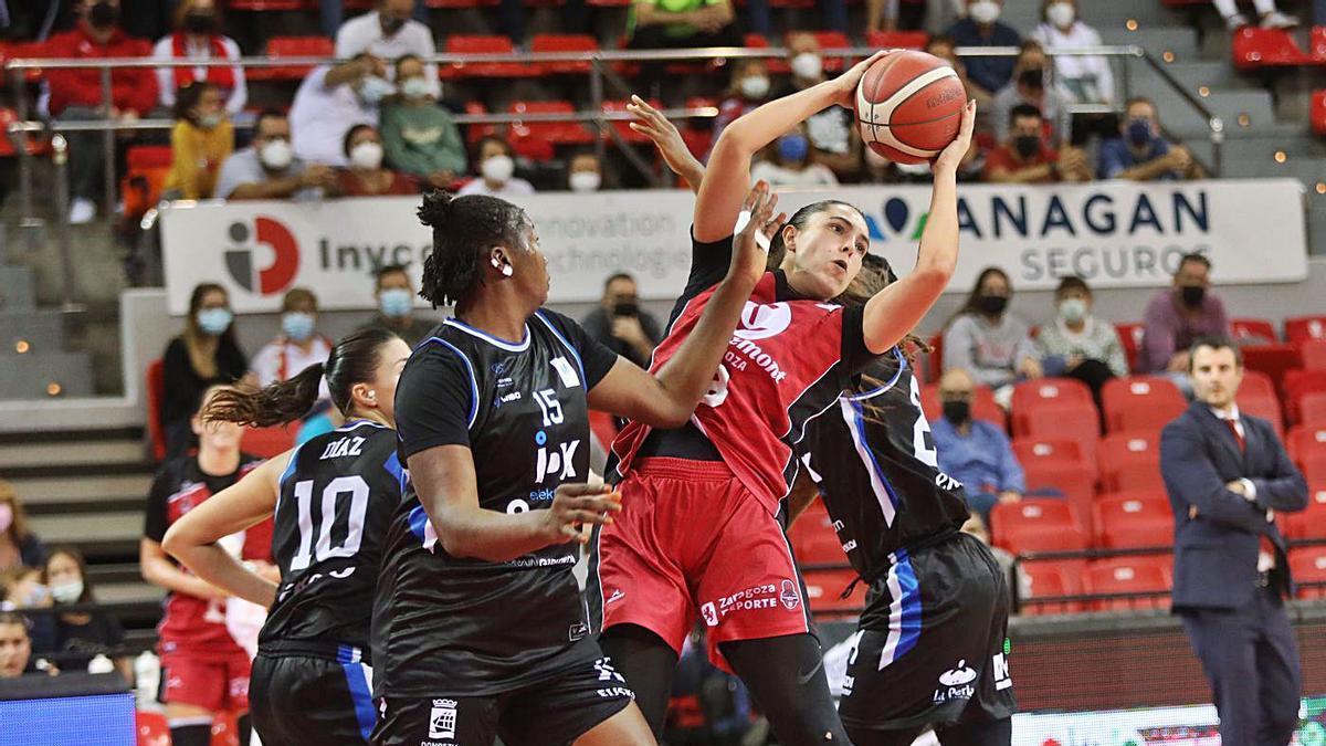 Lara González atrapa un rebote en presencia de Coulibay en el partido ante el Euskotren.