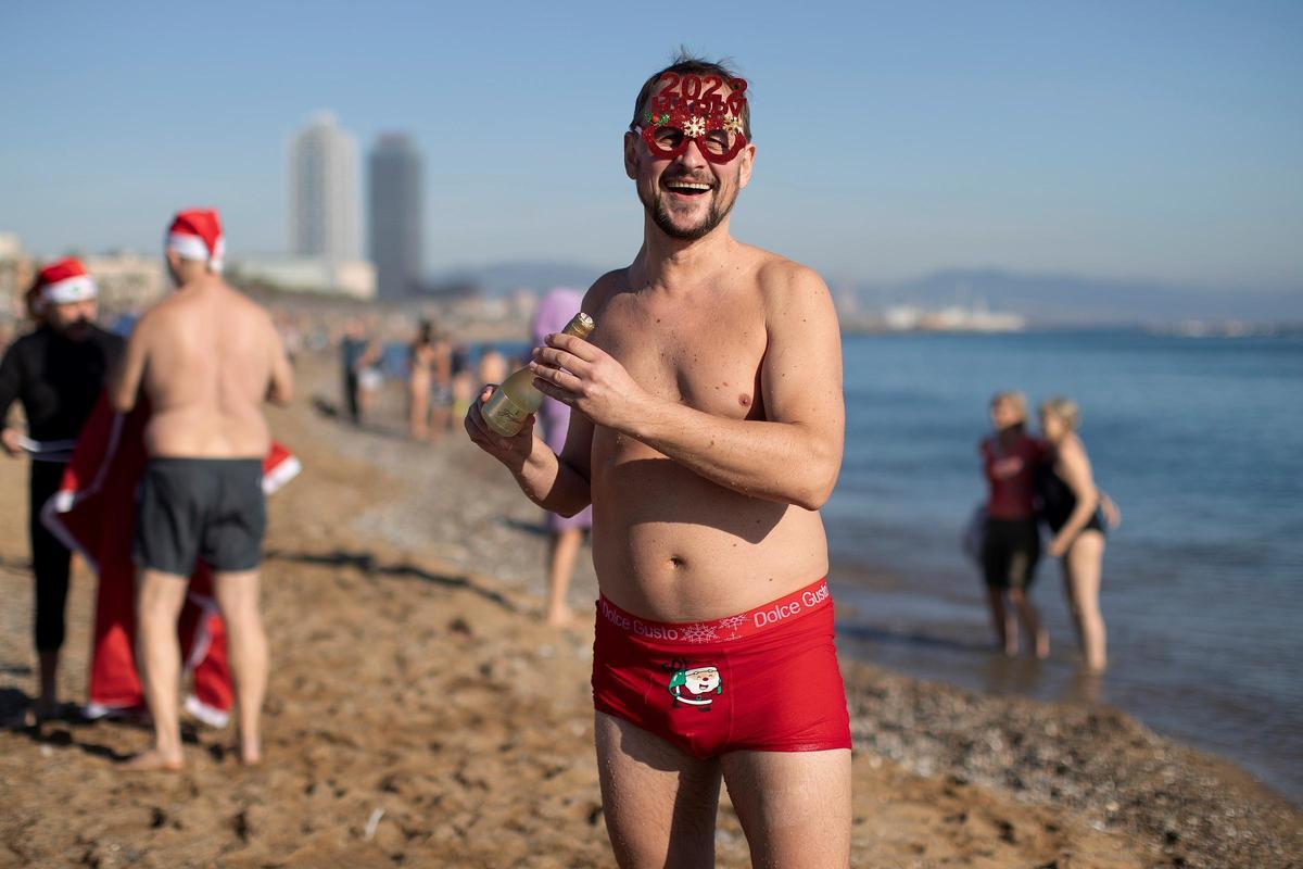 Un hombre en la playa de San Sebastián en Barcelona tras el tradicional primer baño del año.