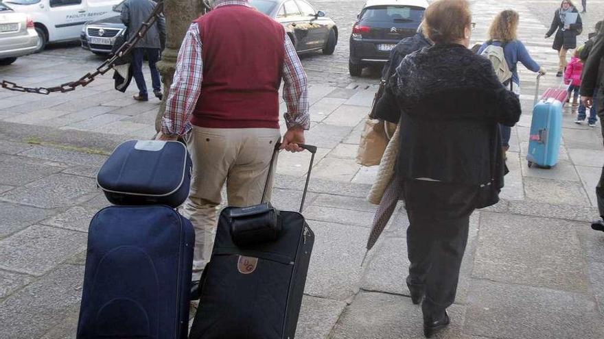 Turistas con maletas en la praza do Obradoiro.