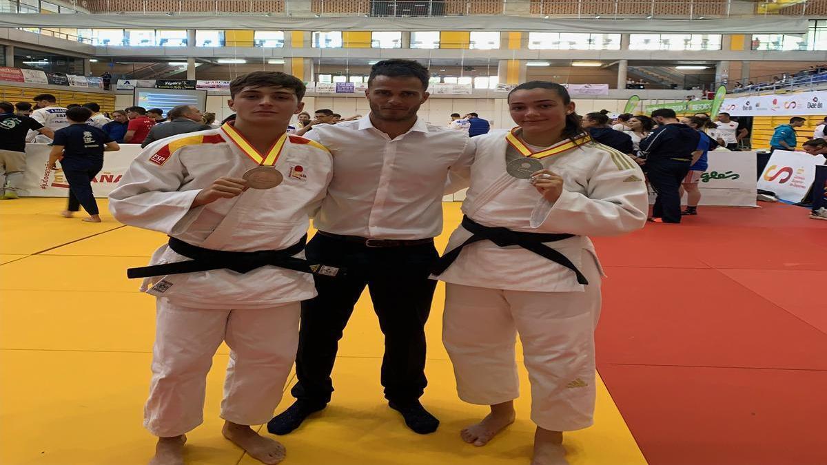 Eric Morales (izd.) y Laura Volo posan con su entrenador Jorge Hernández, con sus respectivas medallas en el Nacional