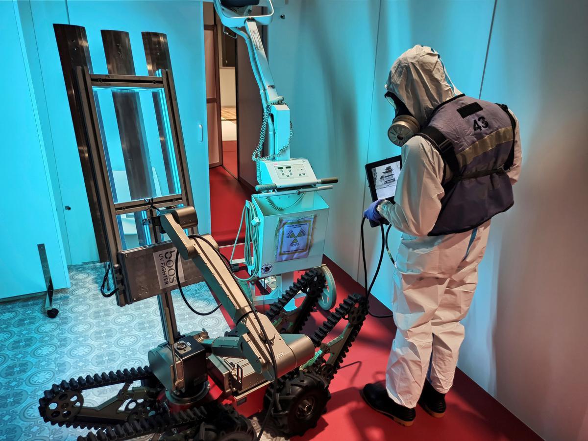 Un soldado de la UME desinfecta una estancia proyectando luz ultravioleta con el robot Teodor en junio de 2020. Los robots militares fueron probados por el Ejército durante la pandemia.