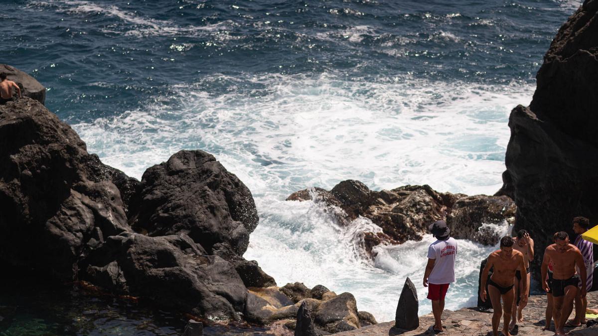 Varias personas se refrescan en el mar.