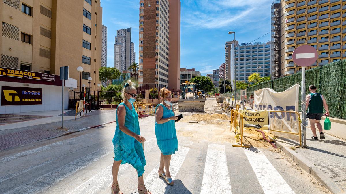 Peatones caminan por una de las obras en marcha en Benidorm.