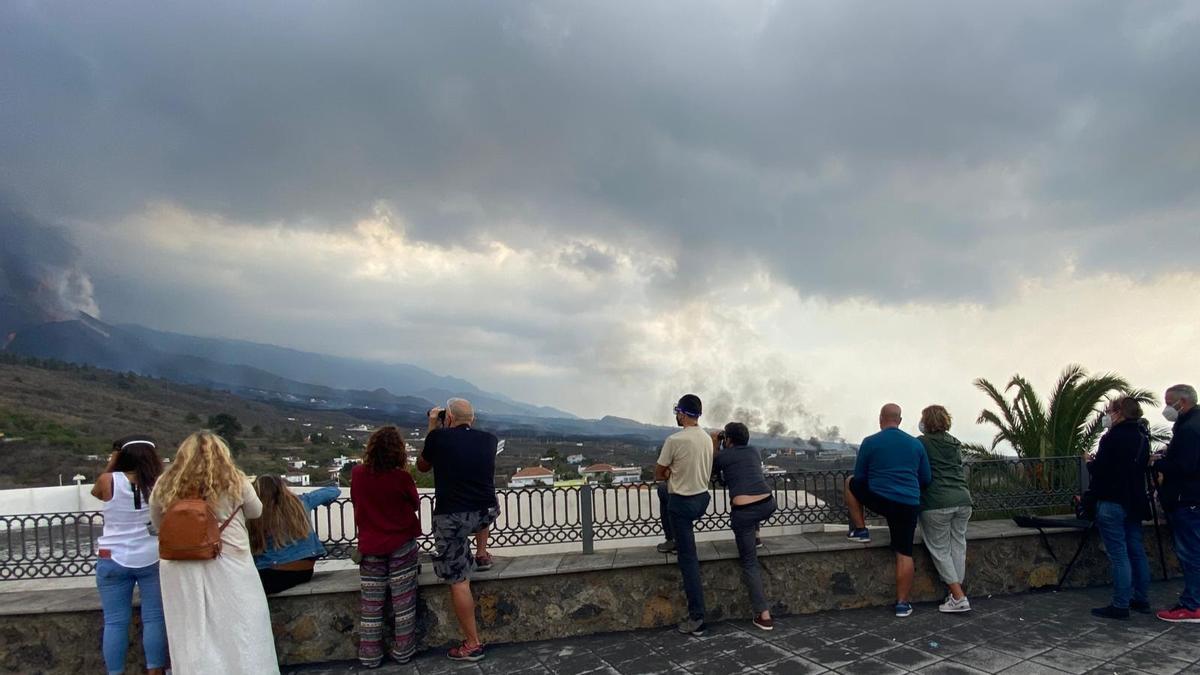 Varias personas contemplan el volcán desde el mirador de Tajuya.