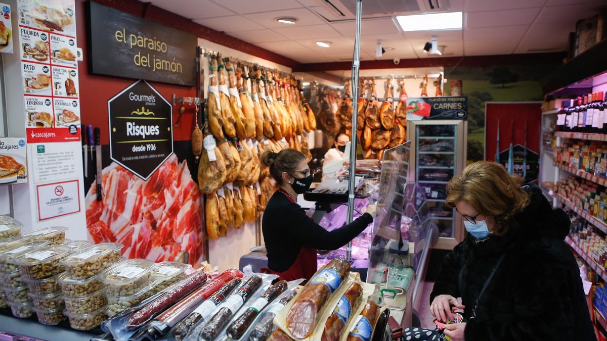 Una mujer paga su compra en una tienda gourmet.