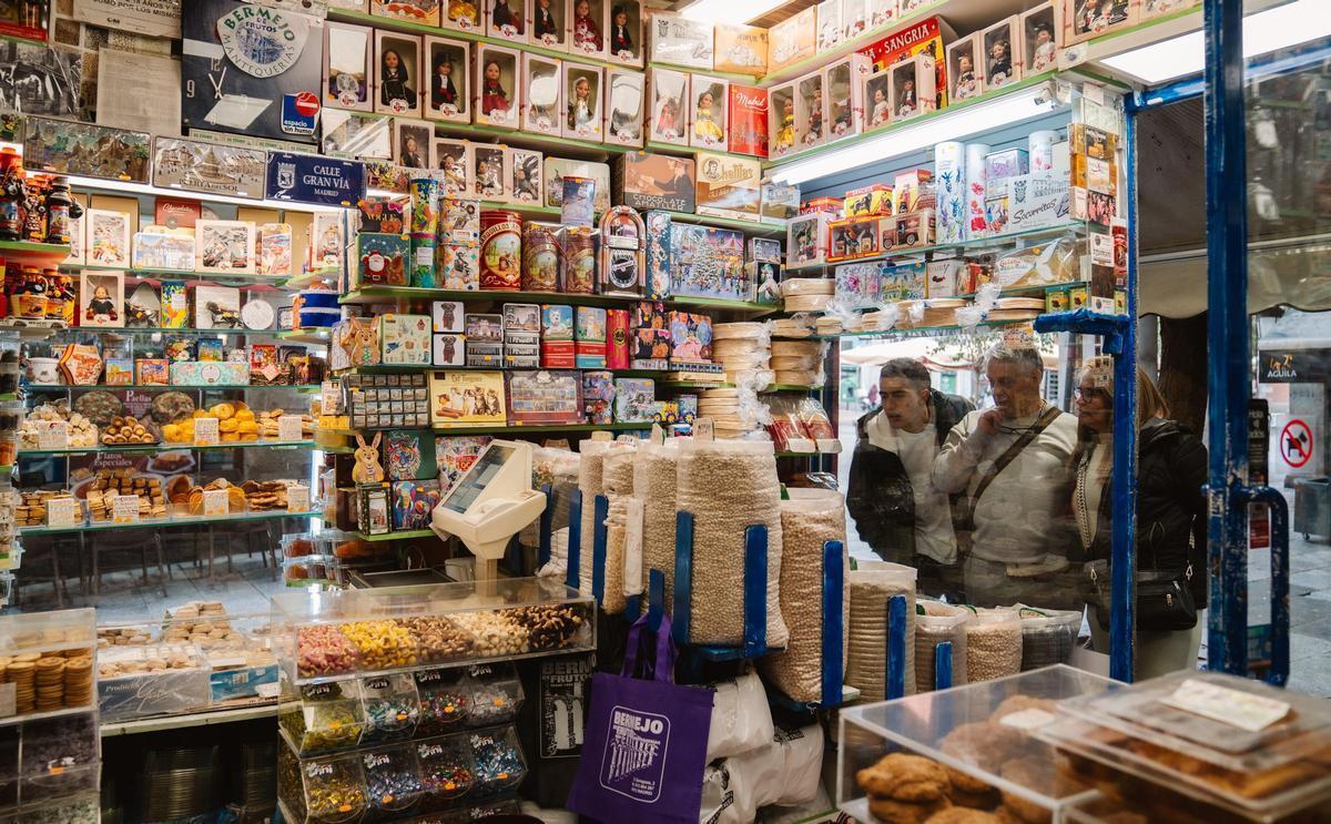 Varios clientes de Mantequería Bermejo, en Madrid, embelesados con unos de los escaparates, donde se exhiben las legumbres.