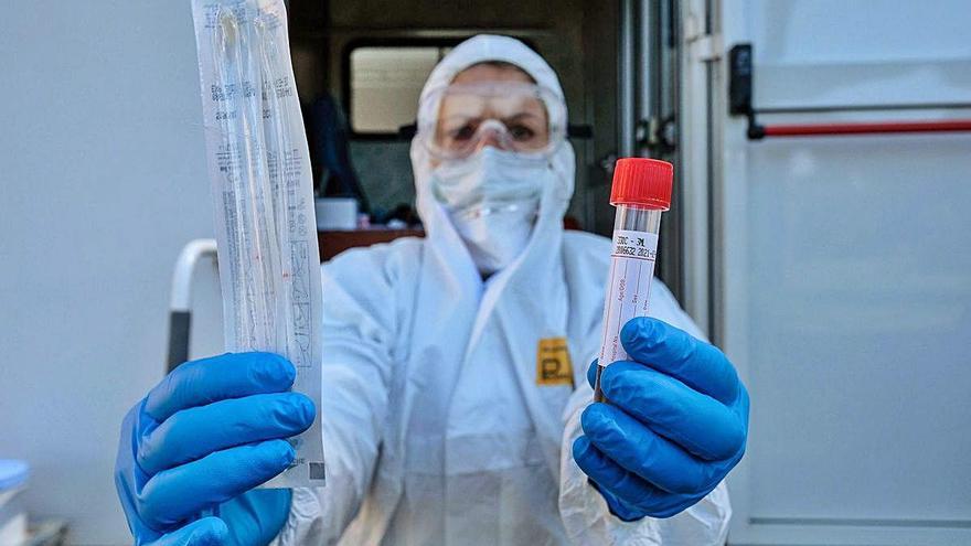 Una trabajadora de un centro romano muestra un test de coronavirus.