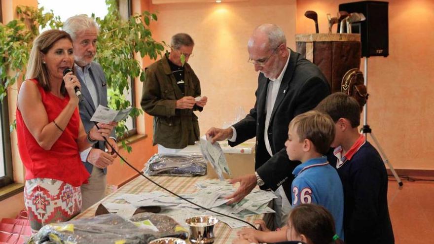 Tres niños ejercen de manos inocentes durante el sorteo de regalos celebrado en la entrega de premios.