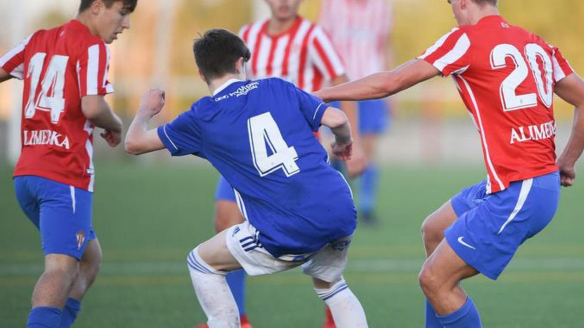 Javi, del Oviedo, pugna con Chousa y Galo, del Sporting, ayer, en el derbi de juveniles en Mareo. | R. S.G.