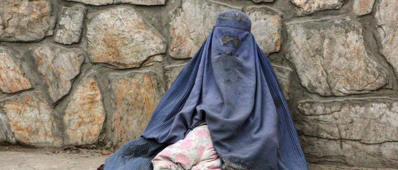 Una mujer afgana mendigando con su hija pequeña escondida bajo el burka en el barrio de Share Naw, en el centro de Kabul.