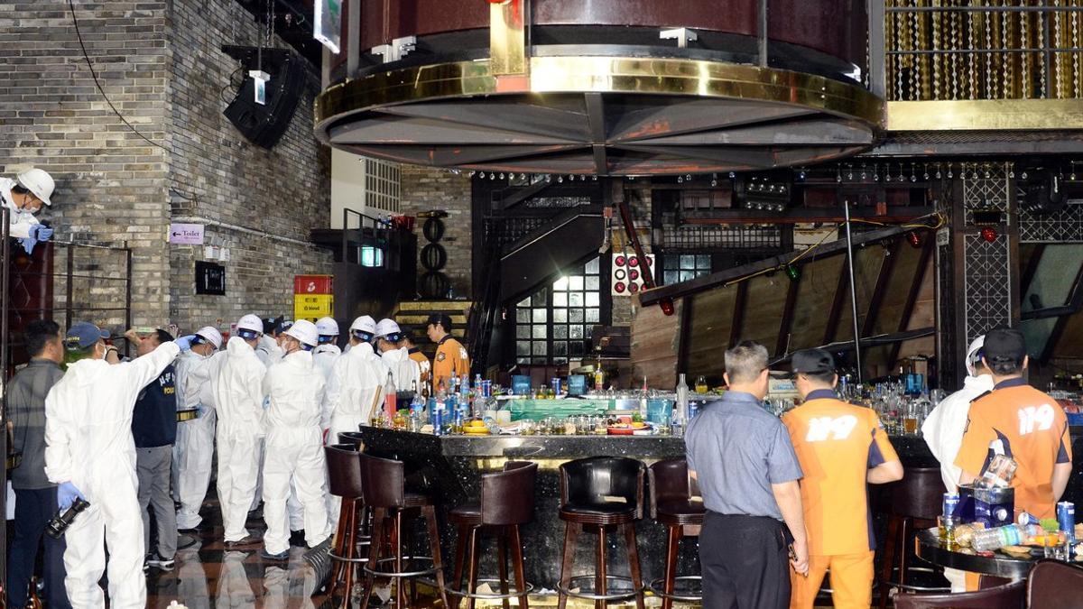 Bomberos y policías inspeccionan el club nocturno de Gwangju donde ocurrió el accidente.