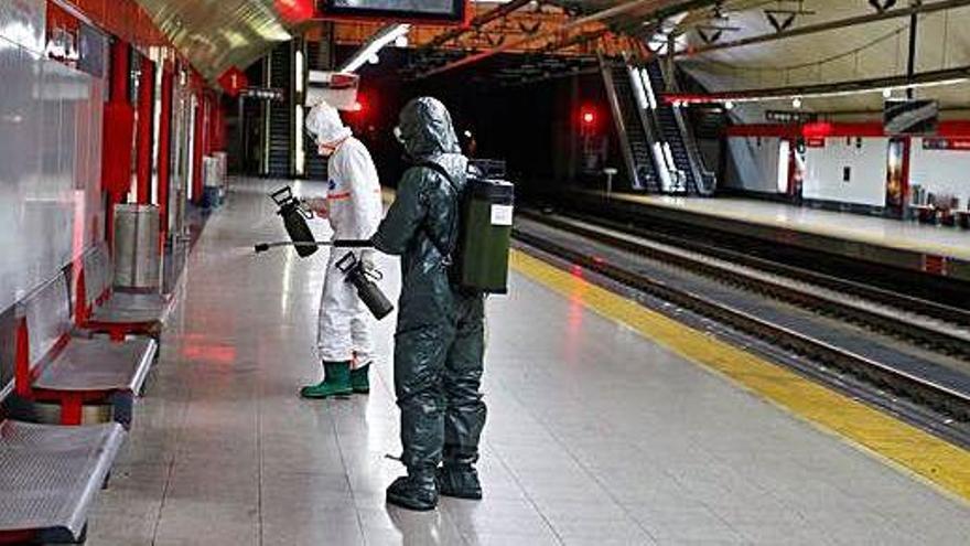Dos militars fent tasques de desinfecció a l&#039;estació de metro de Nuevos Ministerios, a Madrid.