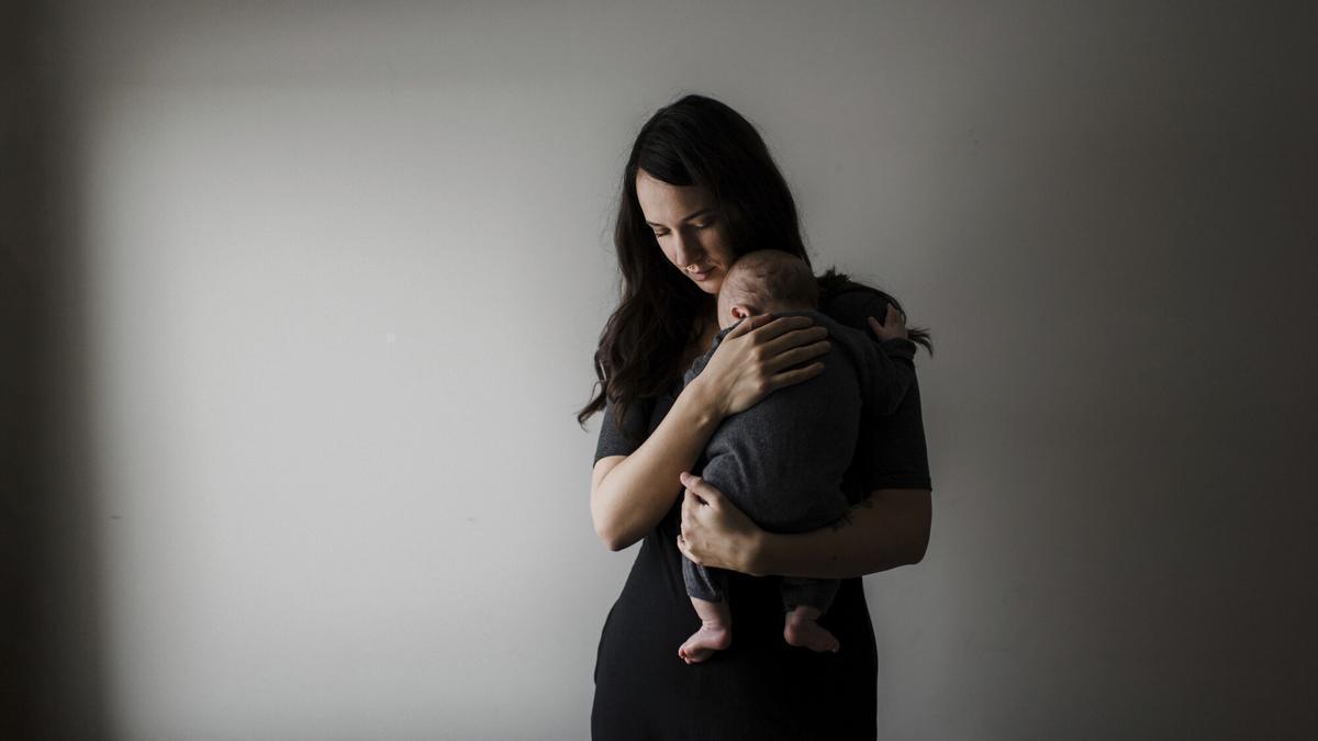 Una mujer, con su hijo en brazos. A tender moment as a mother cradles her sleeping baby. MATERNIDAD. CUIDADOS. BEBE. MADRE