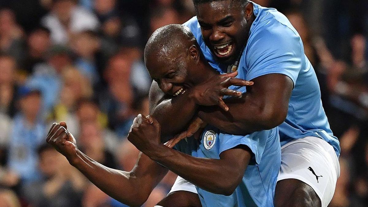 Benjani (L) del Manchester City Legend celebra el segundo gol de su equipo con Micah Richards, en el partido testimonial de Vincent Kompany entre el Manchester City Legends y la Premier League All-stars XI en el estadio Etihad Stadium de Manchester.