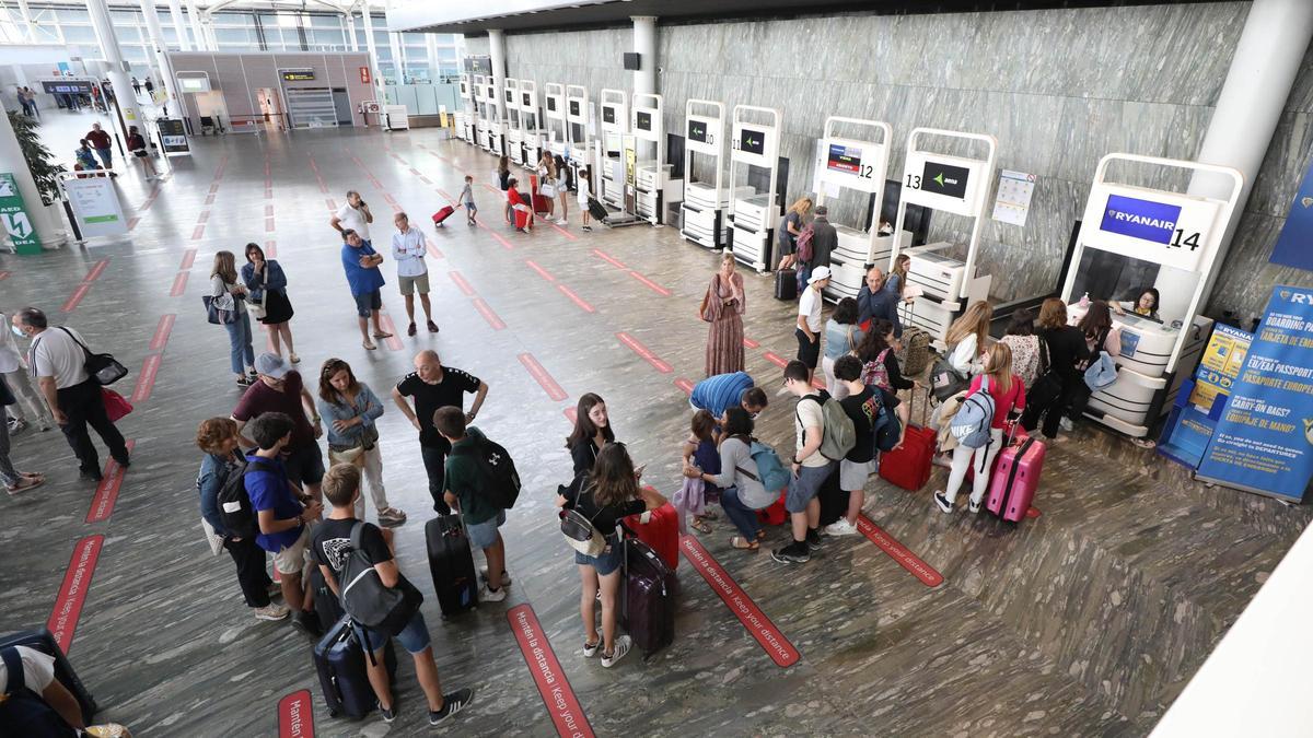 Viajeros en el vestíbulo principal del aeropuerto de Zaragoza esperando a facturar.
