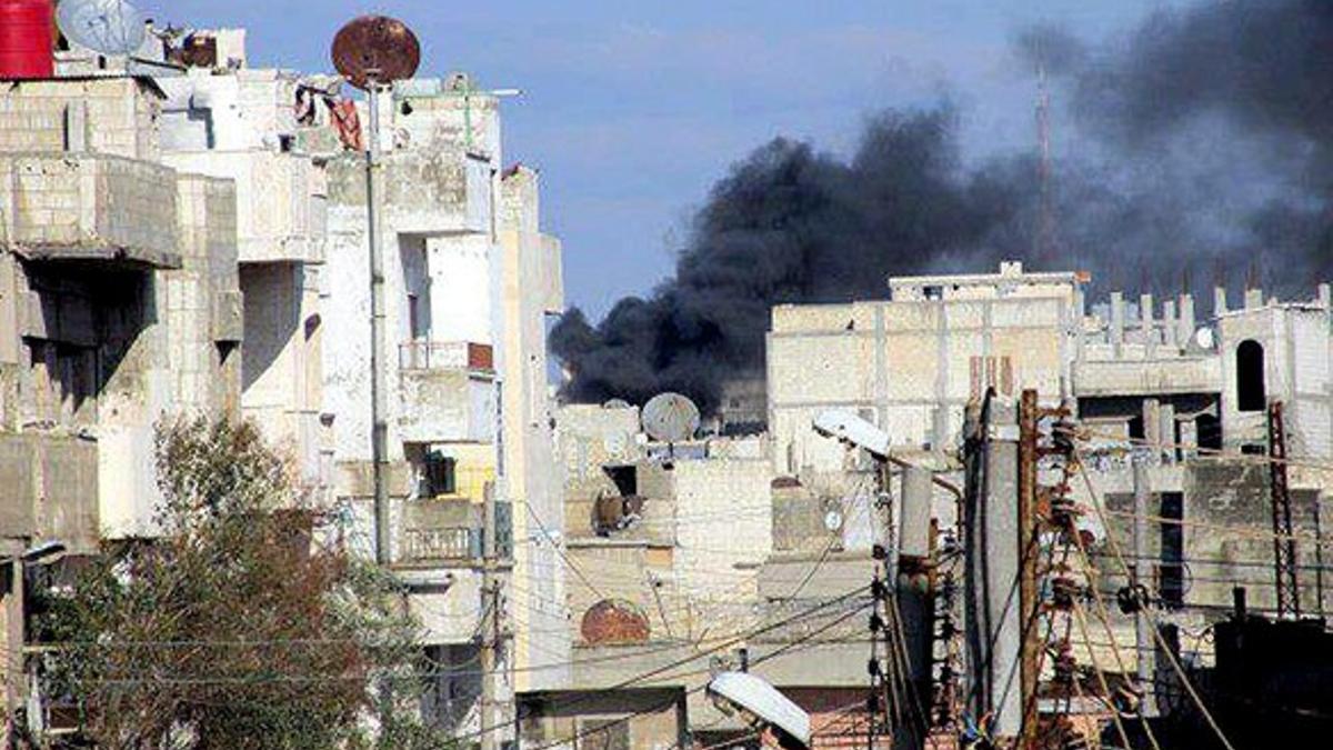 Un edificio en llamas tras ser bombardeado por el Ejército, el domingo en Homs.