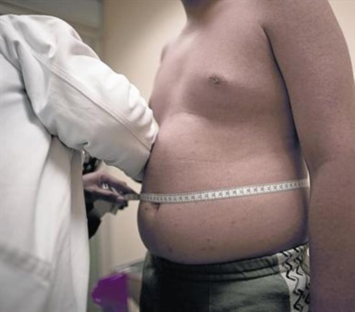 EL MESURAMENT. Un metge mesura el perímetre abdominal a un home que pateix obesitat. EL MESURAMENT. Un metge mesura el perímetre abdominal a un home que pateix obesitat.