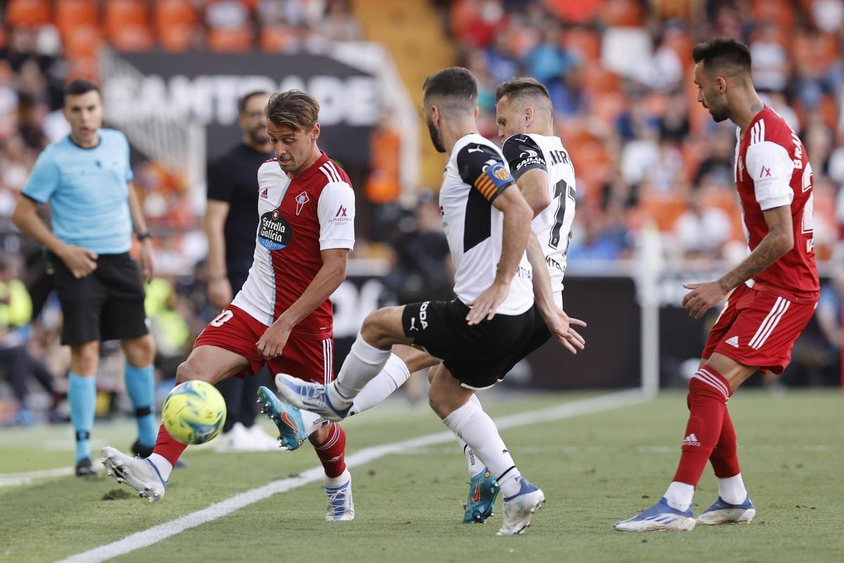 VALENCIA, 21/05/2022.- El defensa del Celta Kevin Vázquez (i) con el balón ante los jugadores del Valencia durante el partido de Liga que disputan en el estadio Mestalla de Valencia. EFE/ Kai Forsterling