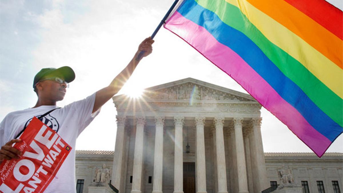 Un ciudadano estadounidense ondea una bandera del orgullo gay, ante en Tribunal Supremo.