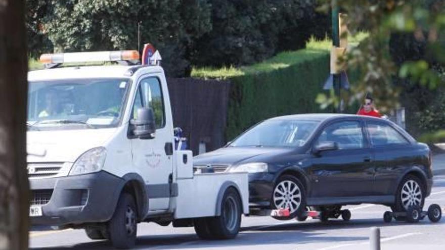 Una grua municipal amb un vehicle retirat.