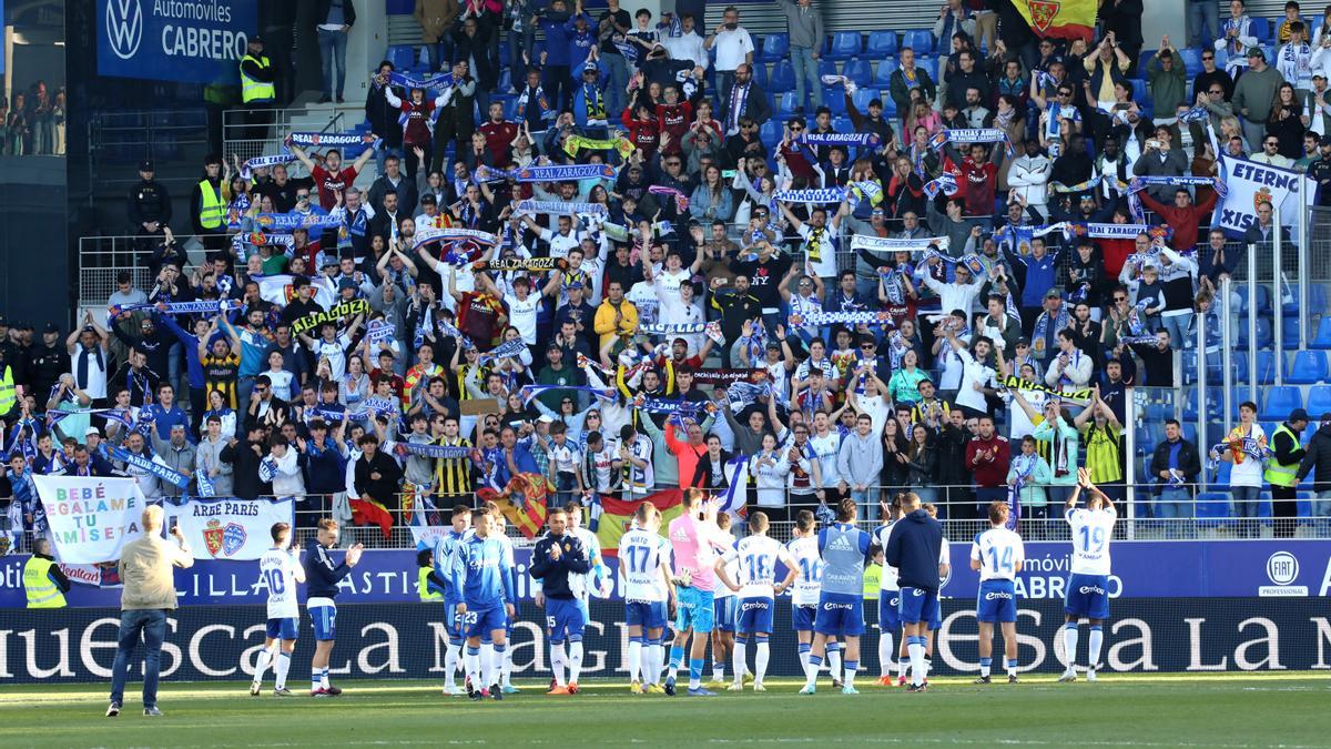 Aficionados zaragocistas en la grada de El Alcoraz reciben el aplauso de los jugadores por su apoyo.