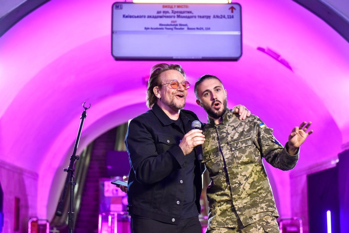 El cantante de U2 Bono cata con un soldado ucraniano en el metro de Kiev, durante un concierto sorpresa