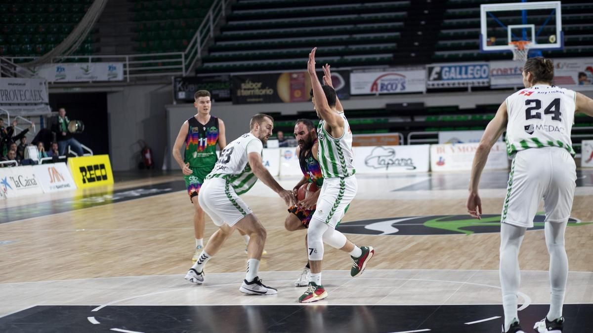 Dani Rodríguez es defendido por dos jugadores del Betis.