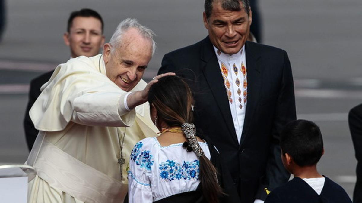 El Papa saluda a uns niños indígenas ante la mirada del presidente de Ecuador, Rafael Correa.