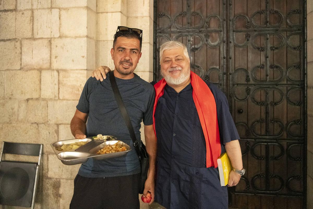 Peio Sánchez, párroco de Santa Anna, junto a un usuario del comedor. Barcelona, 28 de julio de 2026. Foto: Belén González / EP