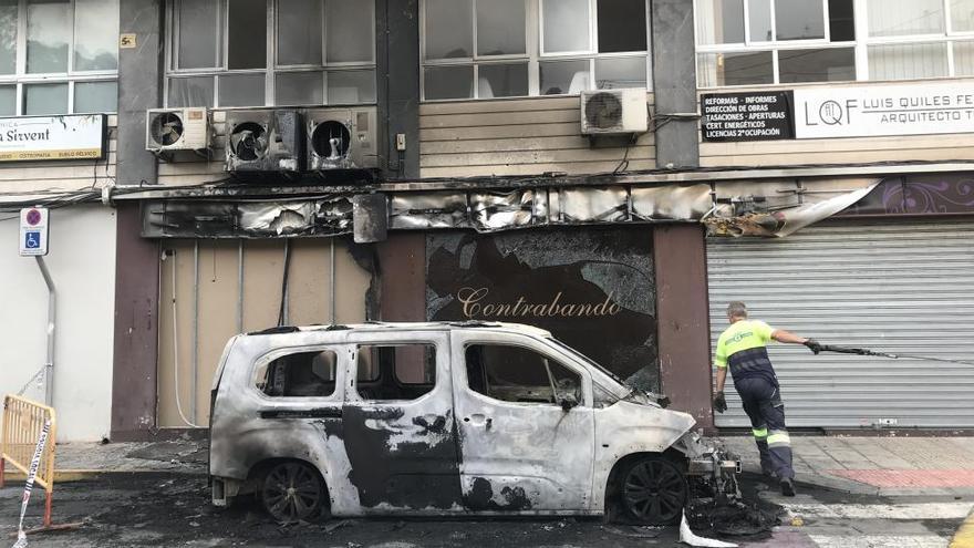 El empleado de la grúa retirando el coche incendiado