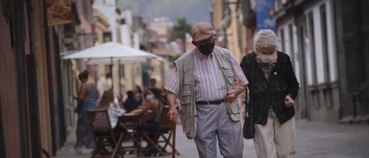 Una pareja con mascarilla pasea por el centro de La Laguna.